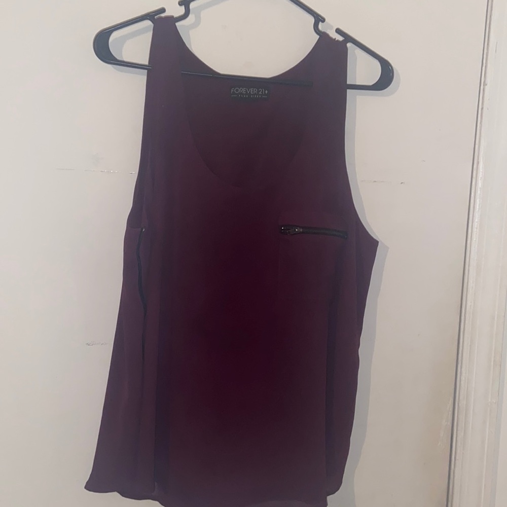 Two layered sleeveless top with zippered pocket and zippers on the sides.